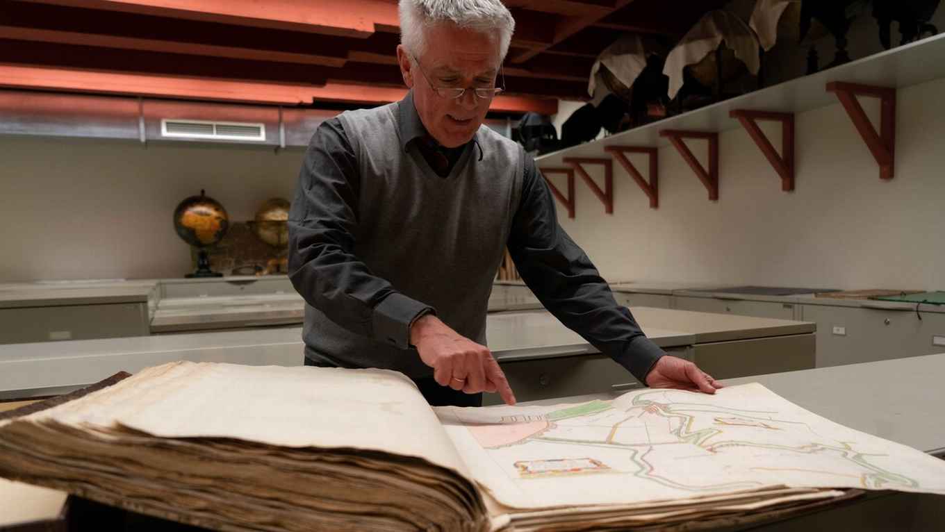 Conservator cartografie Reinder Storm met de Atlas der Neederlanden in het archief van Allard Pierson